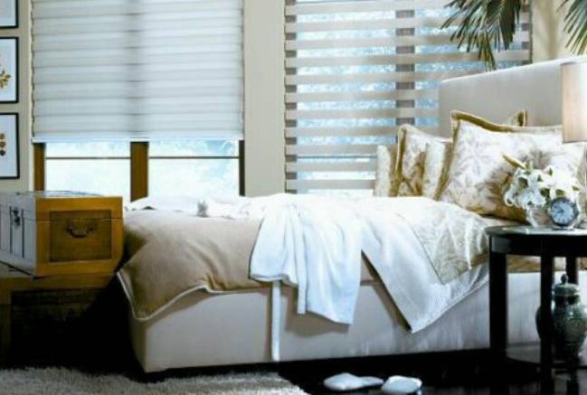 a bedroom with a white bed and a window with blinds